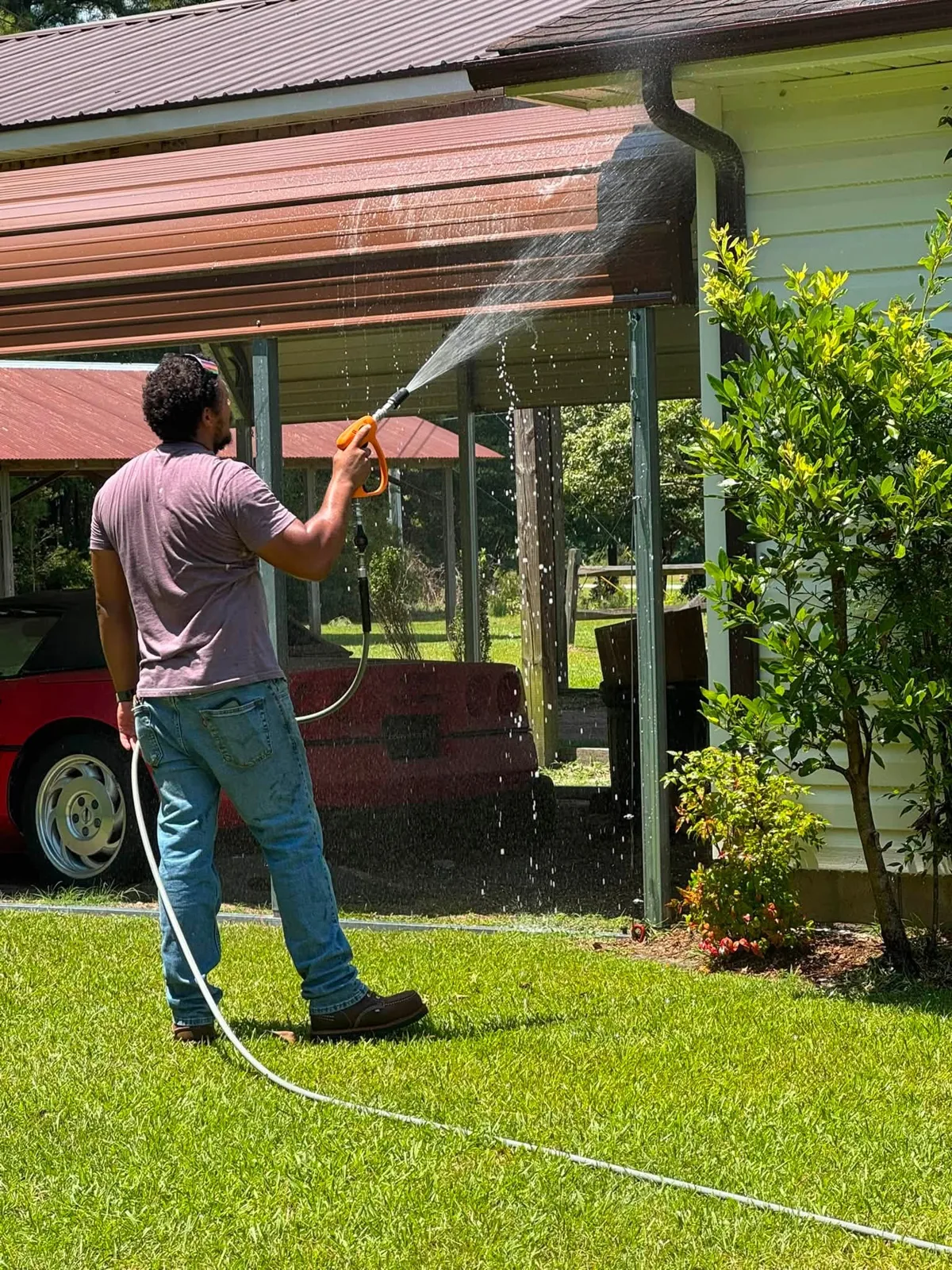 Eric of Ray-Nor-Shine Pro Wash rinsing the eaves and gutters of a Jacksonville NC home